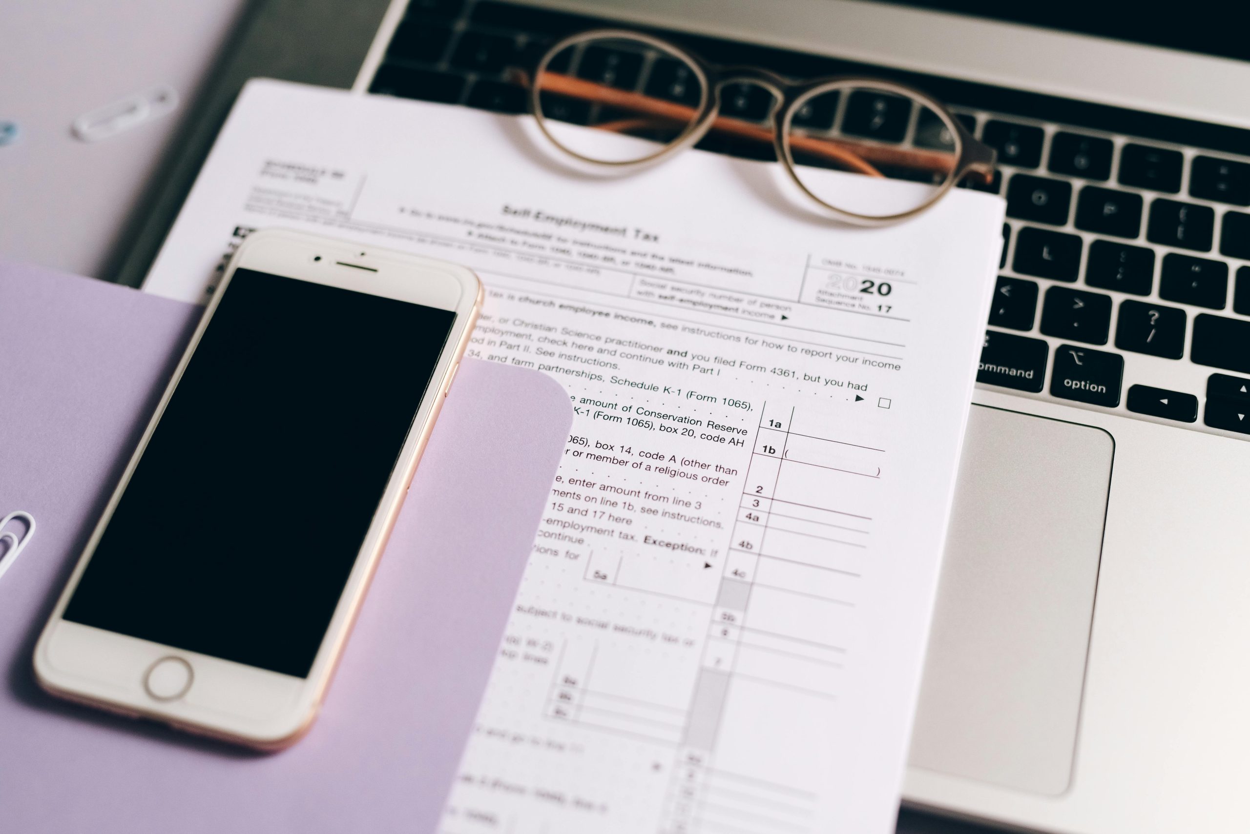 Glasses, phone, laptop and financial documents
