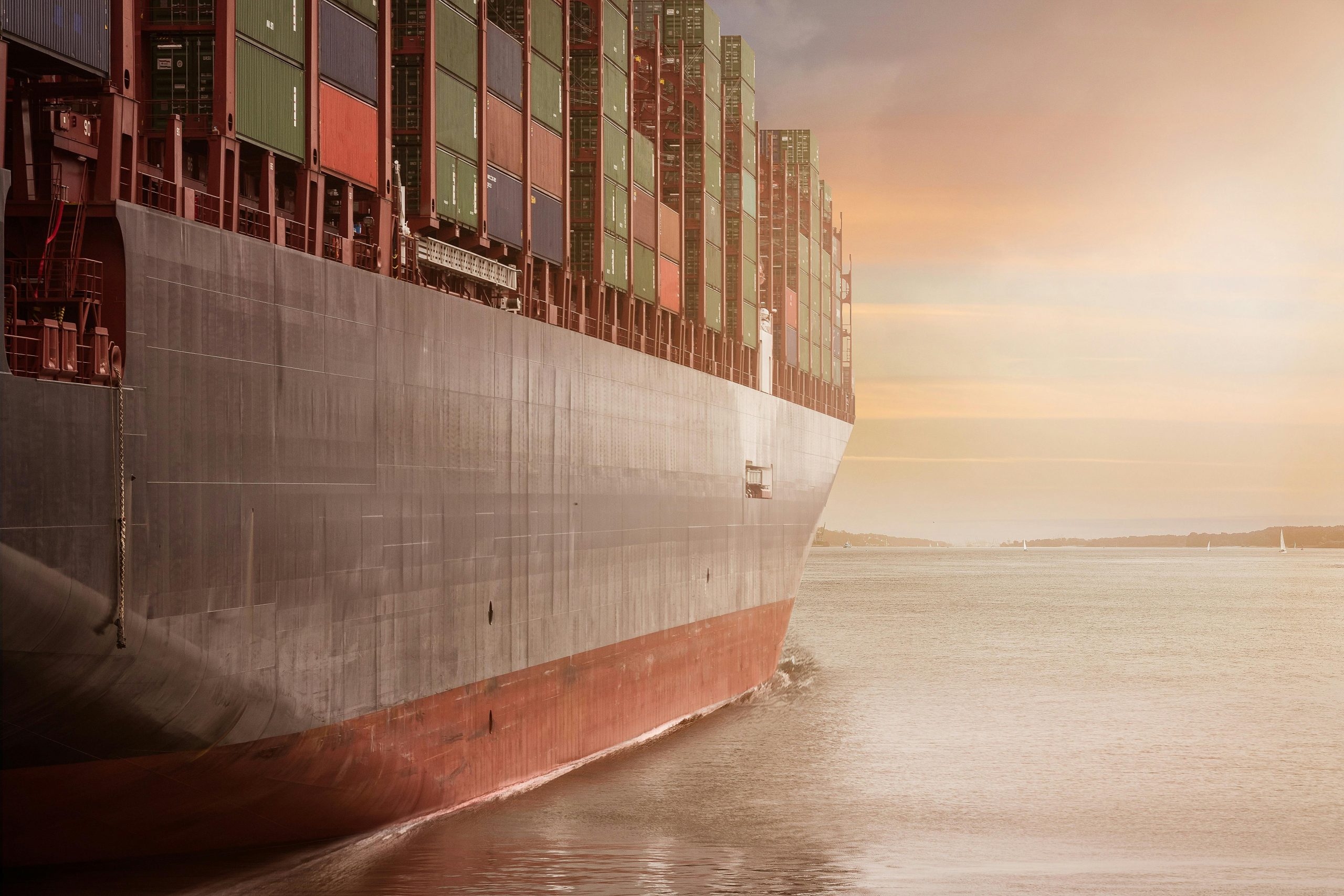 Ship carrying a lot of delivery crates travelling on the ocean